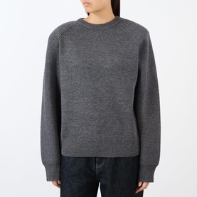 Model wearing The Frankie Shop dark grey wool-blend crew neck sweater with raglan sleeves, styled with dark denim jeans.