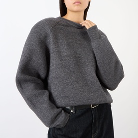 Model wearing The Frankie Shop dark grey wool-blend oversized crew neck sweater with raglan sleeves, styled with black wide-leg trousers.