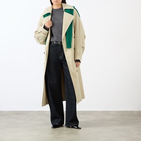 Model wearing The Frankie Shop dark grey wool-blend top, styled with a beige and green colour-block trench coat and wide-leg black jeans.