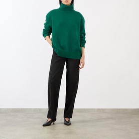Model wearing The Frankie Shop Forest Green alpaca blend turtleneck sweater, styled with black tailored trousers and black kitten heel mules.