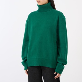 Model wearing The Frankie Shop forest green turtleneck jumper in alpaca-wool blend, oversized fit, with dark trousers.