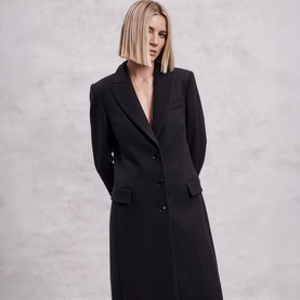 Model wearing The Landskein black longline tailored coat with notched lapels and button fastening, styled with no visible layering