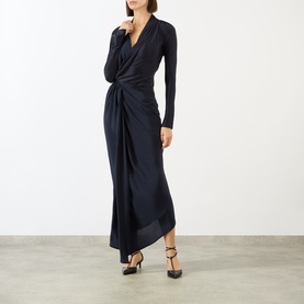 Model wearing Victoria Beckham Lea Gathered Wrap Dress in navy, with draped V-neckline, long sleeves and asymmetric hem, styled with black heels.
