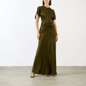 Model wearing Victoria Beckham Dark Green satin gown with ruched waist detail, short split sleeves, and floor-length skirt. Styled with black heeled
