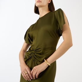 Model wearing Victoria Beckham Dark Green satin gown with ruched waist detail and split sleeves, styled with a gold bangle bracelet.