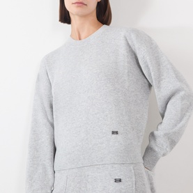 Model wearing Victoria Beckham Grey Marl merino wool and cashmere crew neck knit jumper, styled with matching grey wide-leg trousers