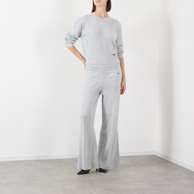 Model wearing Victoria Beckham Grey Marl knit jumper with matching wide-leg trousers and black flat shoes.