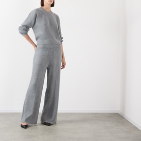 Model wearing Victoria Beckham Mid Grey Marl knit wide-leg trousers, styled with matching grey knit top and black flats.