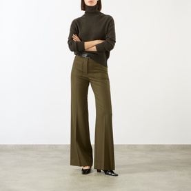 Model wearing Victoria Beckham Marie Turtleneck Sweater in dark green wool, styled with matching wide-leg trousers and black heels