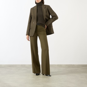 Model wearing Victoria Beckham Marie Turtleneck Sweater in Dark Green, styled with matching dark green wide-leg trousers and black heels.