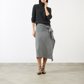 Model wearing Victoria Beckham Marie Turtleneck Sweater in dark grey wool, styled with a grey midi skirt and black heeled sandals.