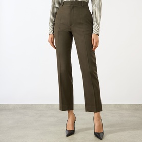 Model wearing Victoria Beckham Straight Leg Cropped Trousers in gold wool, high-rise with pressed creases, styled with a striped blouse and black