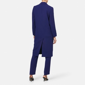 Model wearing Helen McAlinden Ink Blue longline blazer, shown from behind, styled with matching tailored trousers and black heels.