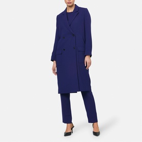 Model wearing Helen McAlinden ink blue double-breasted longline coat, styled with matching tapered trousers and black heels.