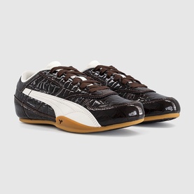 Dark brown croc-embossed patent leather Puma low-top trainers with cream stripe detail and gum sole, angled pair view