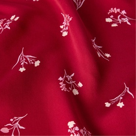 Whistles red fabric with delicate white floral sprig print, shown as a close-up of the dress material.