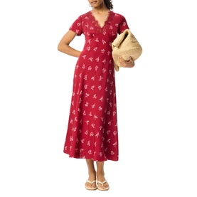 Model wearing Whistles red floral midi dress with short sleeves and V-neckline, styled with a woven bag and white sandals.