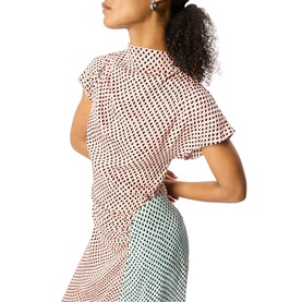 Model wearing Whistles pink polka dot short-sleeve top with flutter sleeves, styled with a printed midi skirt
