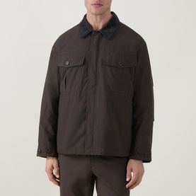 Model wearing Snow Peak Dark Brown casual jacket with contrast collar and dual chest pockets, styled with matching trousers.