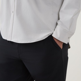 Model wearing Snow Peak ivory casual shirt, styled with black trousers. Close-up detail of cuff and side seam.