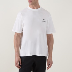 Model wearing Snow Peak off white crew neck T-shirt with small chest logo print, styled with black trousers.