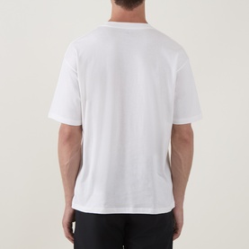 Model wearing Snow Peak off white T-shirt, rear view, relaxed fit with short sleeves, styled with black trousers