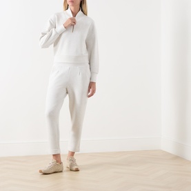 Model wearing Varley Ivory Marl sweatshirt and matching joggers, styled with beige trainers