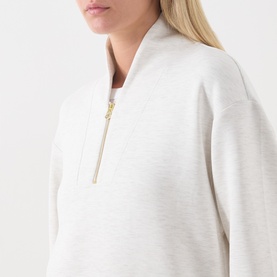 Model wearing Varley Ivory Marl sweatshirt with gold half-zip detail, relaxed fit, close-up of neckline and zip.