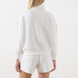 Model wearing Varley Ivory Marl sweatshirt, back view, with matching Ivory Marl shorts. Relaxed fit with mock neck and dropped shoulders.