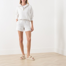 Model wearing Varley Ivory Marl sweat shorts with matching half-zip sweatshirt, styled with cream chunky flatform sandals.