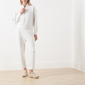 Model wearing Varley Ivory Marl sweatshirt and matching joggers, styled with beige trainers