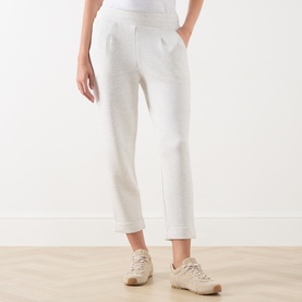 Model wearing Varley Ivory Marl sweat trousers with cuffed hem and front pleats, styled with beige trainers.