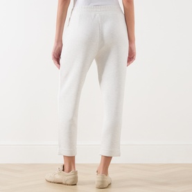 Model wearing Varley Ivory Marl sweatpants, cropped length with cuffed hem, styled with cream trainers.
