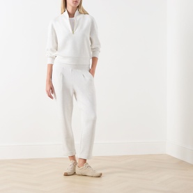 Model wearing Varley Ivory Marl sweatpants styled with matching half-zip sweatshirt and beige trainers.