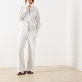 Model wearing Varley Ivory Marl sweatpants with matching zip-up top, styled with burgundy stripe trainers.