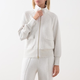 Model wearing Varley Ivory Marl zip-up sweat jacket with funnel neck and front pockets, styled with matching wide-leg joggers.