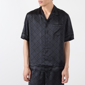Model wearing Casablanca black silk casual shirt with diamond jacquard pattern, short sleeves, and camp collar, styled with matching trousers