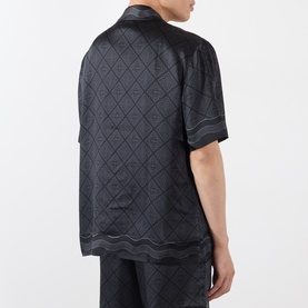 Model wearing Casablanca black silk casual shirt with all-over diamond jacquard pattern, short sleeves and contrast stitching trim, back view