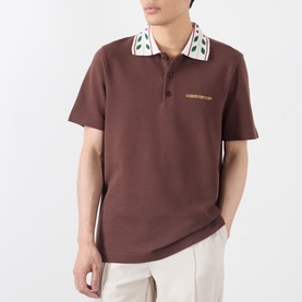 Model wearing Casablanca brown cotton polo with patterned leaf collar and chest embroidery, styled with cream trousers