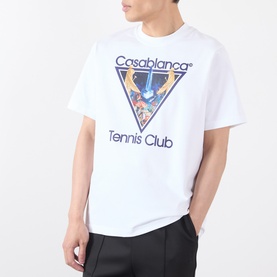 Model wearing white Casablanca Tennis Club graphic T-shirt with triangular print, styled with black trousers.