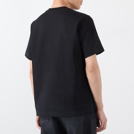 Model wearing black crew neck short sleeve T-shirt, back view, styled with dark denim jeans