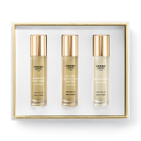 Creed fragrance gift set with three gold-capped bottles including Aventus For Her, Silver Mountain Water, and Fleurissimo in presentation box
