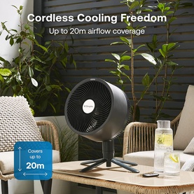 Dimplex black cordless desk fan on tripod stand, shown outdoors on patio table with up to 20m airflow coverage