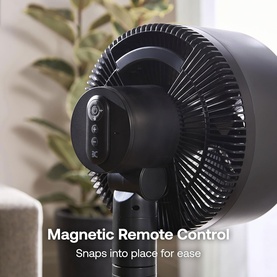 Dimplex black pedestal fan with magnetic remote control that snaps onto the stand, shown in a home setting
