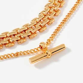Mint Velvet gold layered chain necklace set with panther-link and curb chains, featuring a T-bar pendant
