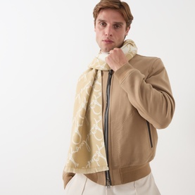 Model with Burberry sand wool scarf featuring large monogram print, styled with a beige zip-up jacket