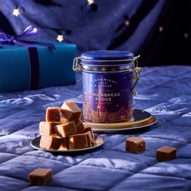 Cartwright & Butler Gingerbread Fudge in festive navy blue clip-top tin, with fudge pieces displayed on a gold plate