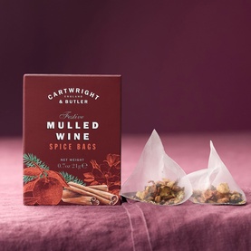 Cartwright & Butler Mulled Wine Spice Bags in red box with two pyramid spice bags displayed on a pink linen surface