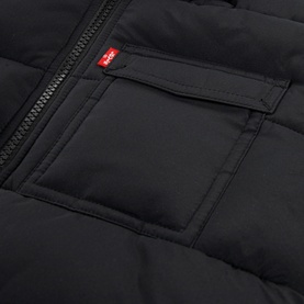 Levi's children's black quilted outerwear jacket, close-up of chest pocket with zip detail and red brand tab