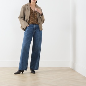 Model wearing Paige Hickory Multi silk blouse with wide-leg blue jeans, tan blazer, and black kitten heel boots.